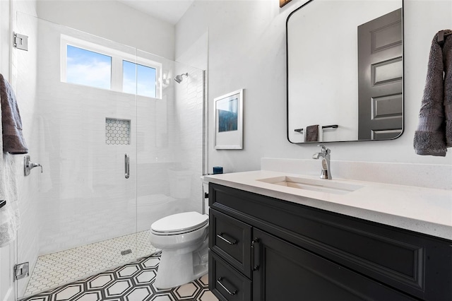 bathroom featuring a shower with shower door, tile floors, toilet, and vanity with extensive cabinet space