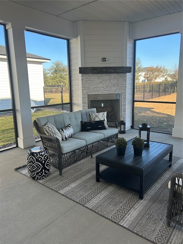 sunroom with a wealth of natural light and an outdoor stone fireplace