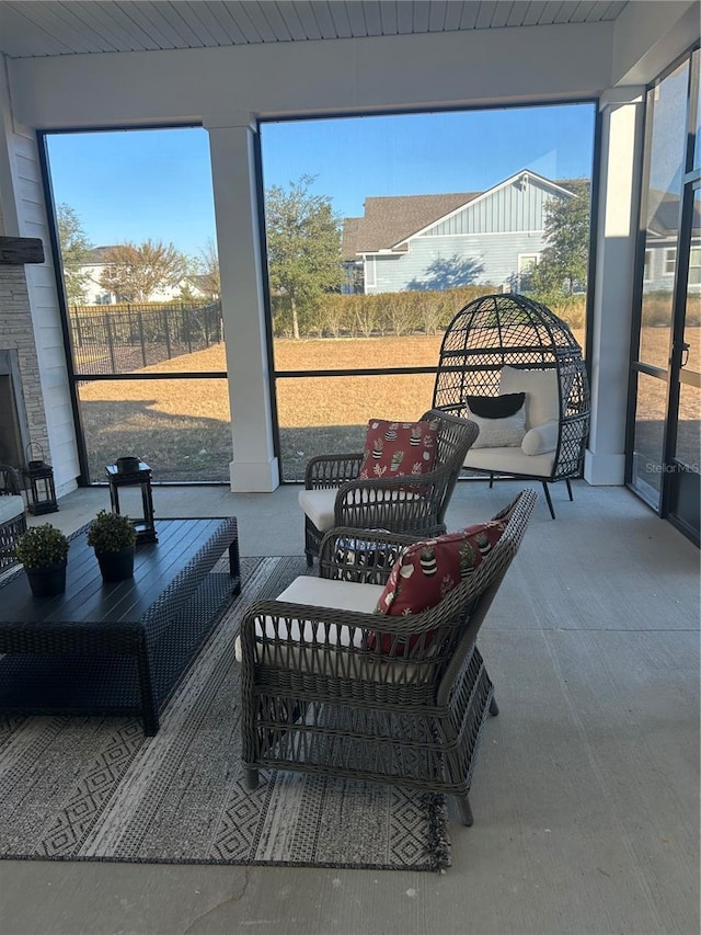 sunroom / solarium with exterior fireplace and wood ceiling