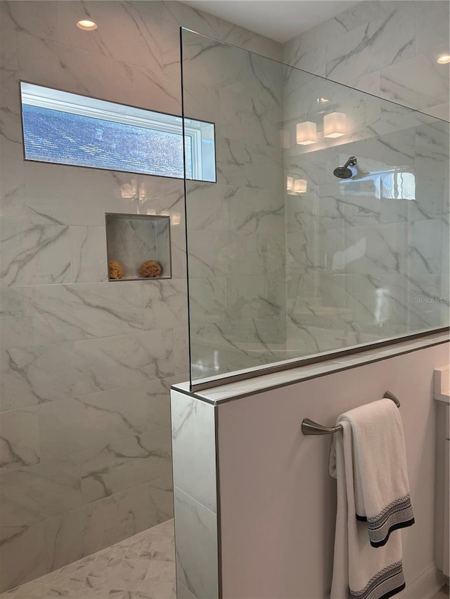 bathroom featuring a tile shower, vanity, and plenty of natural light