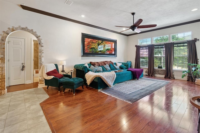 living room featuring ornamental molding, tile floors, and ceiling fan