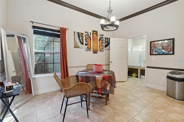 tiled dining space featuring ornamental molding, washer / dryer, and a chandelier