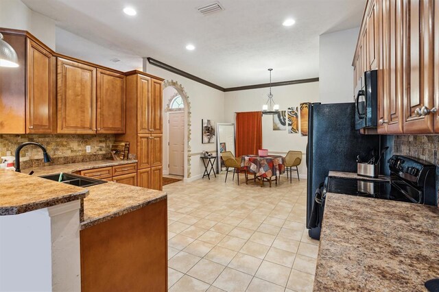 kitchen with backsplash, black appliances, sink, pendant lighting, and light tile floors