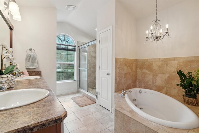 bathroom with a healthy amount of sunlight, vaulted ceiling, dual bowl vanity, and tile floors