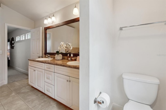 bathroom featuring vanity with extensive cabinet space, tile floors, double sink, toilet, and lofted ceiling