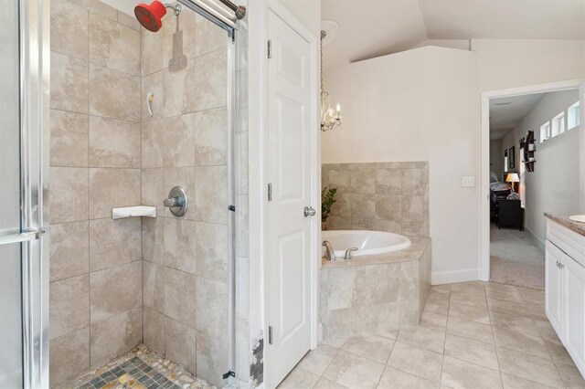 bathroom featuring tile flooring, lofted ceiling, vanity, and shower with separate bathtub