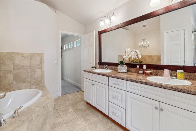 bathroom featuring vanity with extensive cabinet space, tiled tub, double sink, tile floors, and vaulted ceiling