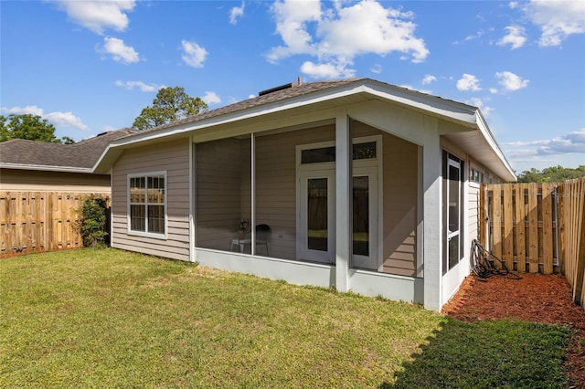 back of property with a yard and a sunroom