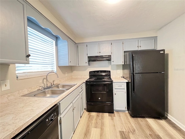 kitchen with gray cabinets, black appliances, sink, and light wood-type flooring