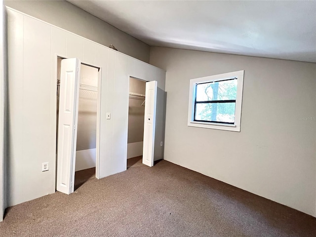 unfurnished bedroom with carpet floors and lofted ceiling