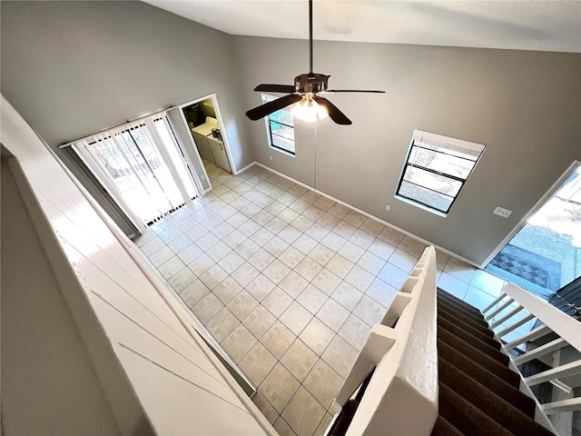 foyer with high vaulted ceiling, ceiling fan, light tile floors, and a wealth of natural light