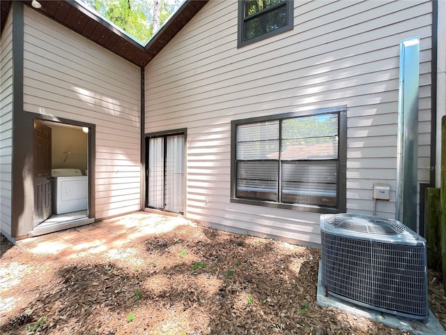 rear view of house with washer and dryer and central AC unit