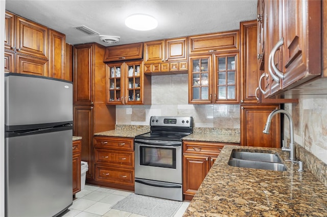 kitchen with tasteful backsplash, light stone countertops, sink, and stainless steel appliances