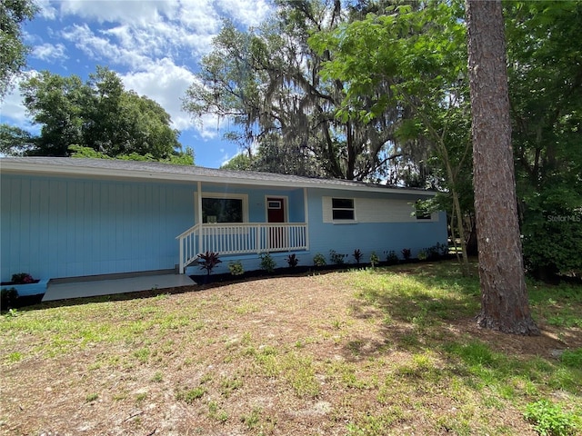 back of house with a yard and covered porch