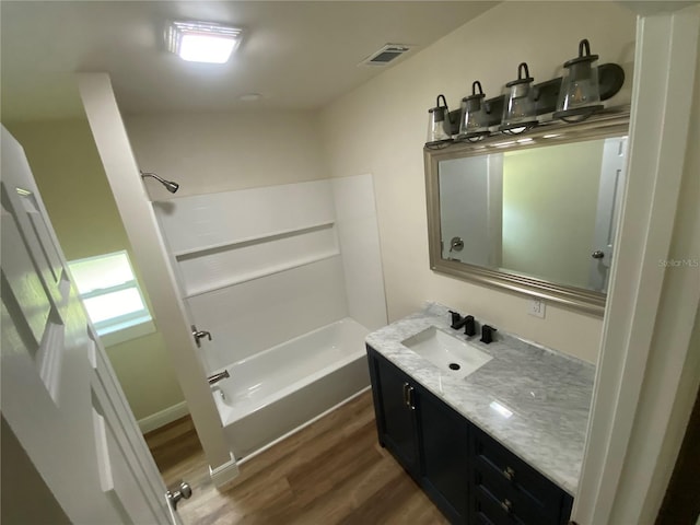 bathroom featuring bathing tub / shower combination, hardwood / wood-style floors, and vanity