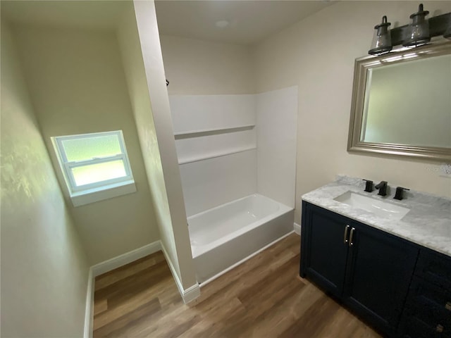 bathroom with bathtub / shower combination, hardwood / wood-style floors, and vanity