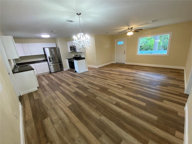 unfurnished living room with hardwood / wood-style flooring, ceiling fan with notable chandelier, and sink