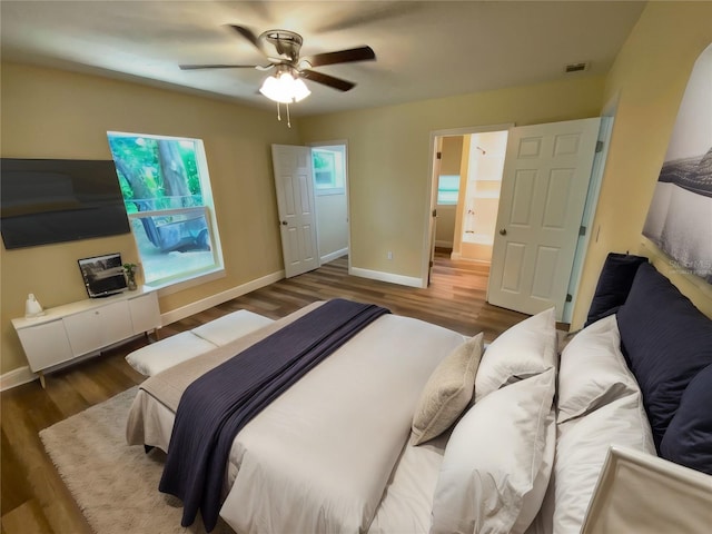 bedroom featuring ensuite bath, ceiling fan, and dark wood-type flooring