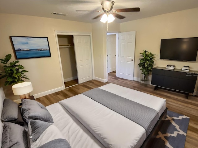 bedroom with dark hardwood / wood-style flooring, a closet, and ceiling fan