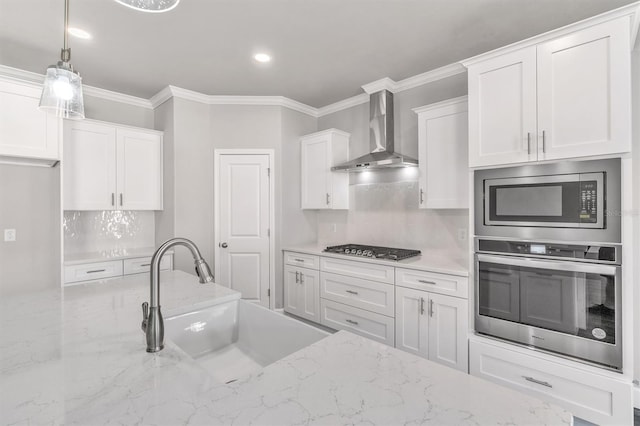 kitchen featuring wall chimney range hood, light stone countertops, tasteful backsplash, and stainless steel appliances