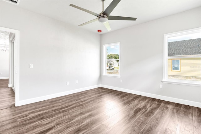 unfurnished room with plenty of natural light, ceiling fan, and dark hardwood / wood-style floors