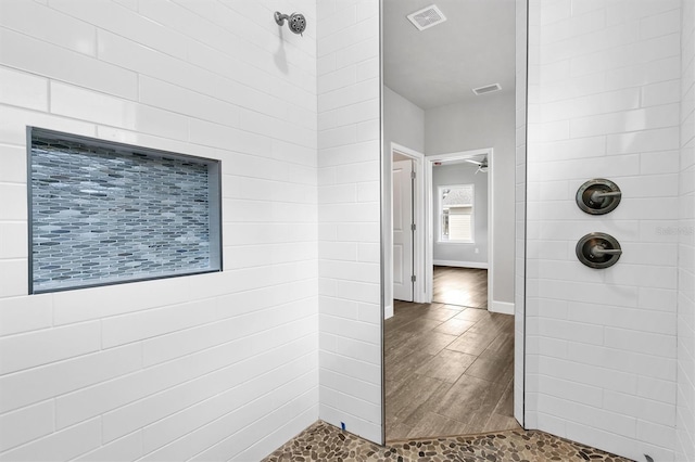 bathroom featuring a tile shower and hardwood / wood-style flooring