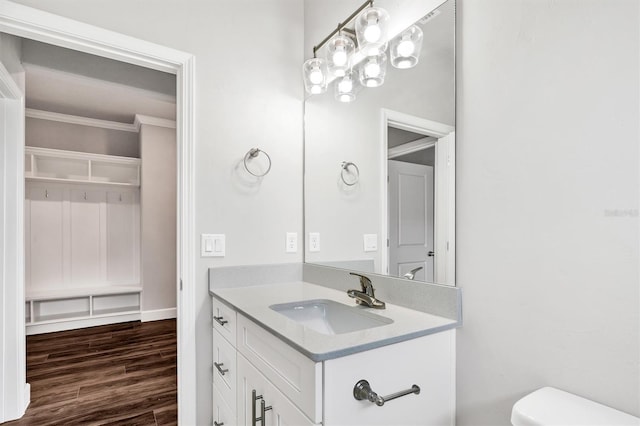 bathroom featuring crown molding, hardwood / wood-style flooring, large vanity, and toilet