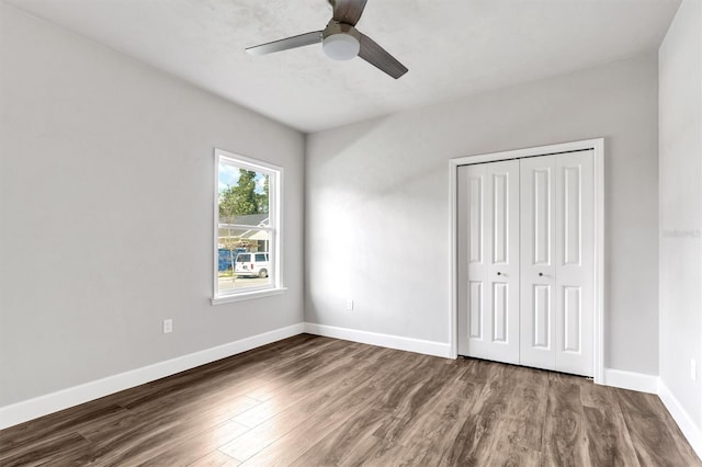 unfurnished bedroom with hardwood / wood-style floors, a closet, and ceiling fan