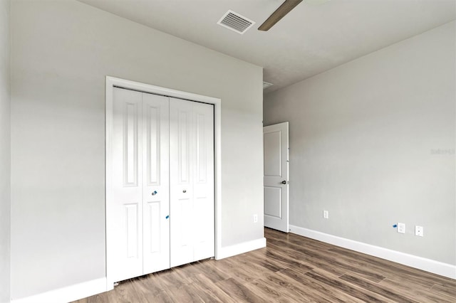 unfurnished bedroom featuring wood-type flooring, a closet, and ceiling fan