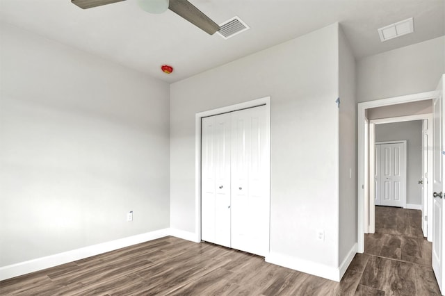 unfurnished bedroom with dark hardwood / wood-style floors, ceiling fan, and a closet