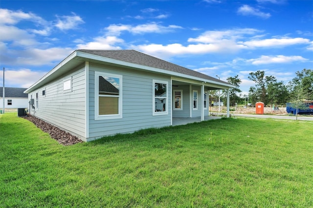 back of house featuring central AC and a lawn