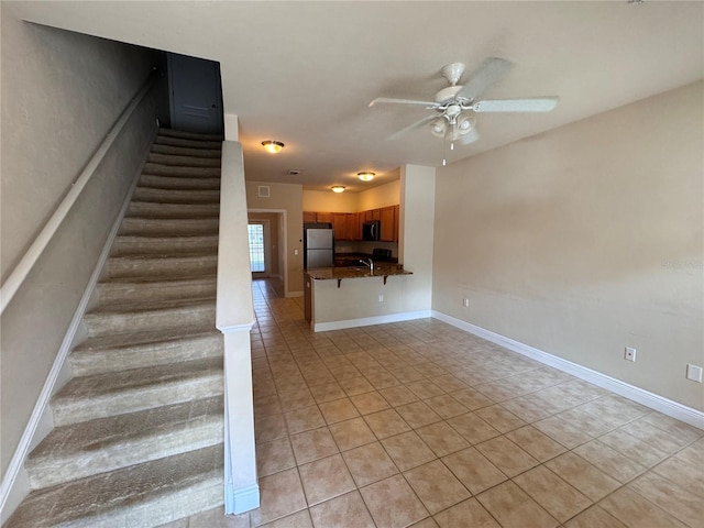 staircase featuring ceiling fan and tile patterned flooring