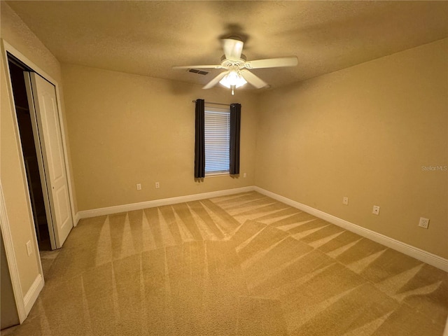 unfurnished bedroom with carpet floors, a closet, a textured ceiling, and ceiling fan