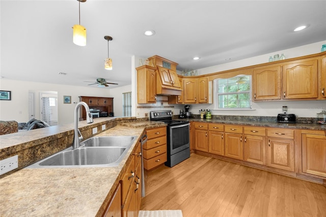 kitchen featuring decorative light fixtures, appliances with stainless steel finishes, sink, ceiling fan, and light wood-type flooring