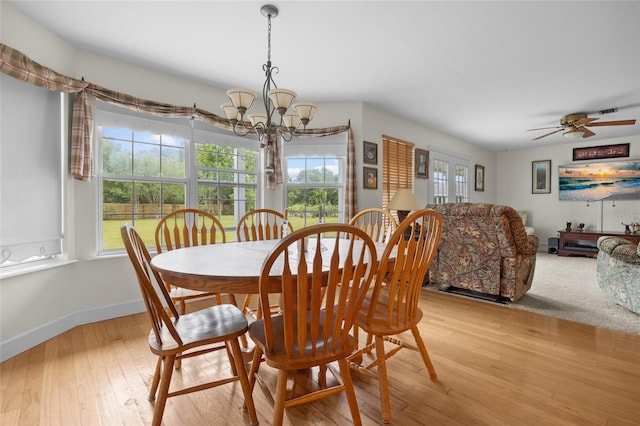 dining room featuring a wealth of natural light, ceiling fan with notable chandelier, and light wood-type flooring