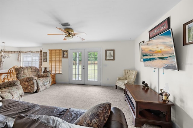 living room featuring ceiling fan, light carpet, and french doors