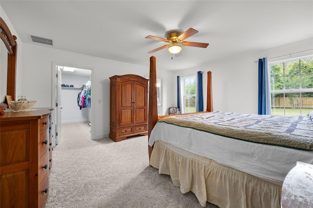 carpeted bedroom featuring a closet, ceiling fan, and a spacious closet