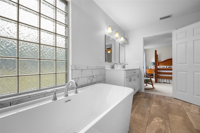 bathroom featuring a tub to relax in and vanity