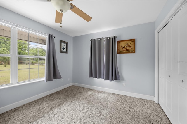 unfurnished bedroom with light colored carpet, ceiling fan, and a closet