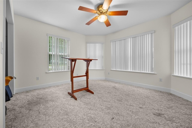 interior space with carpet flooring and ceiling fan