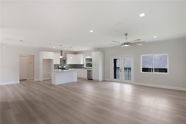 unfurnished living room featuring sink, light wood-type flooring, and ceiling fan