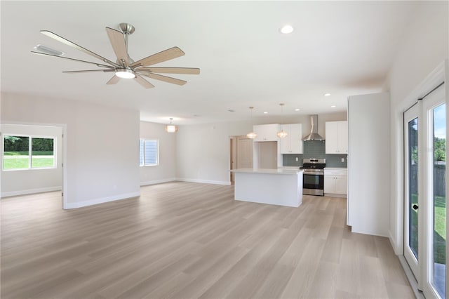 unfurnished living room featuring ceiling fan and light hardwood / wood-style flooring