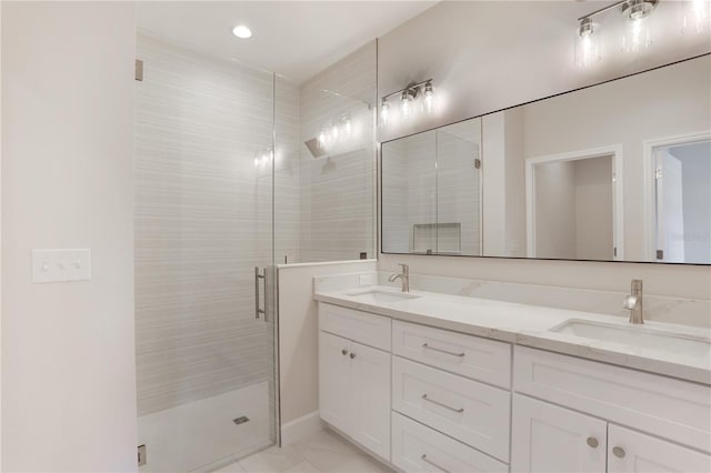 bathroom with tile flooring, vanity with extensive cabinet space, an enclosed shower, and double sink