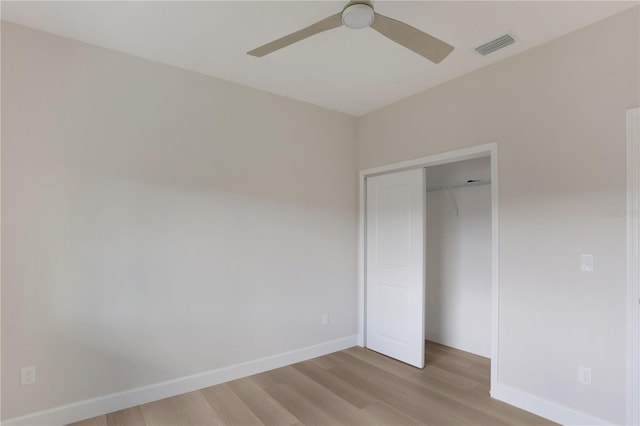 unfurnished bedroom featuring ceiling fan, a closet, and hardwood / wood-style flooring