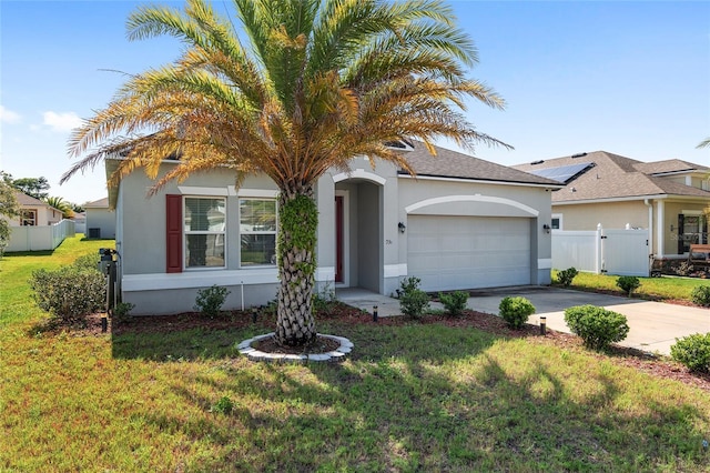 view of front of property with a garage, a front yard, and solar panels