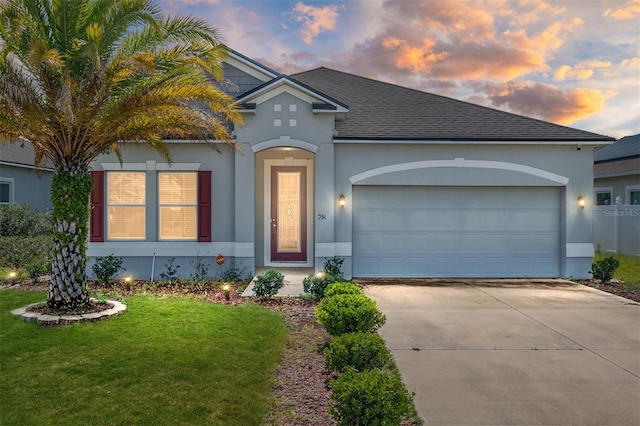 view of front of property featuring a garage and a yard