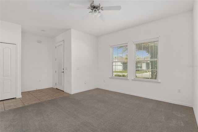 tiled spare room featuring ceiling fan