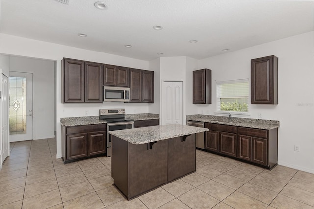 kitchen featuring a center island, stainless steel appliances, dark brown cabinets, a breakfast bar, and sink