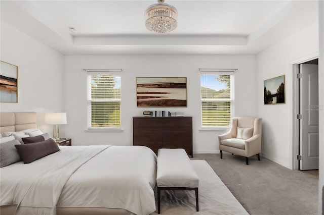 bedroom with a chandelier, carpet flooring, and a raised ceiling