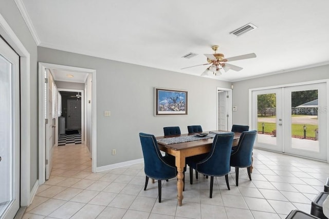 tiled dining room with ceiling fan, crown molding, and french doors